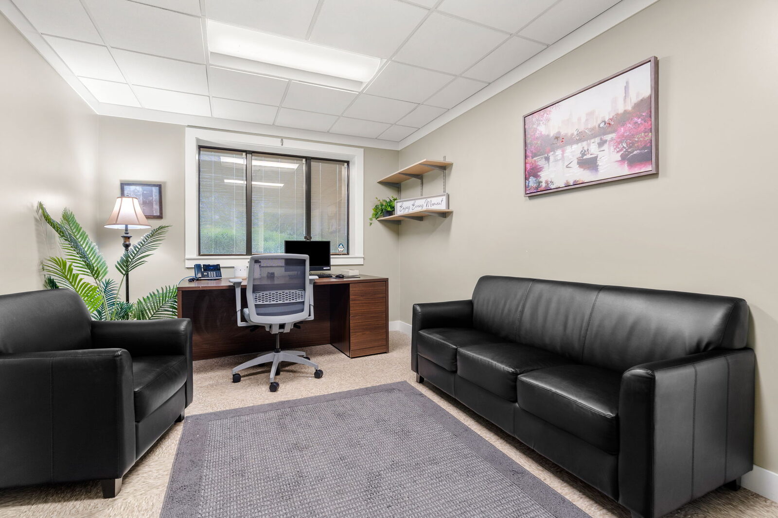 Counseling office with a desk, sofa and armchair